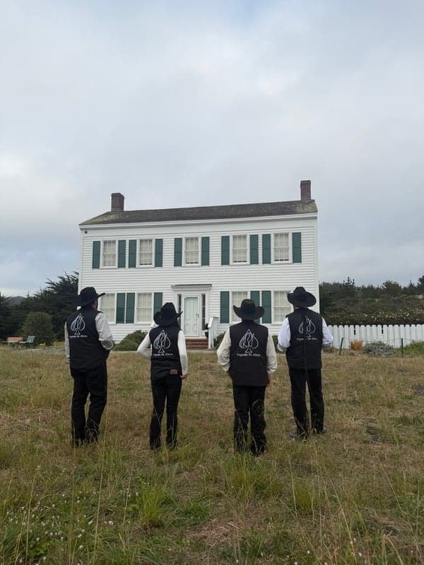 Felix Jimenez and others facing the Johnston House from the field