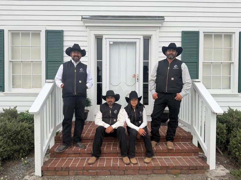 Joaquin Jimenez and family standing on the porch steps of the Johnston House
